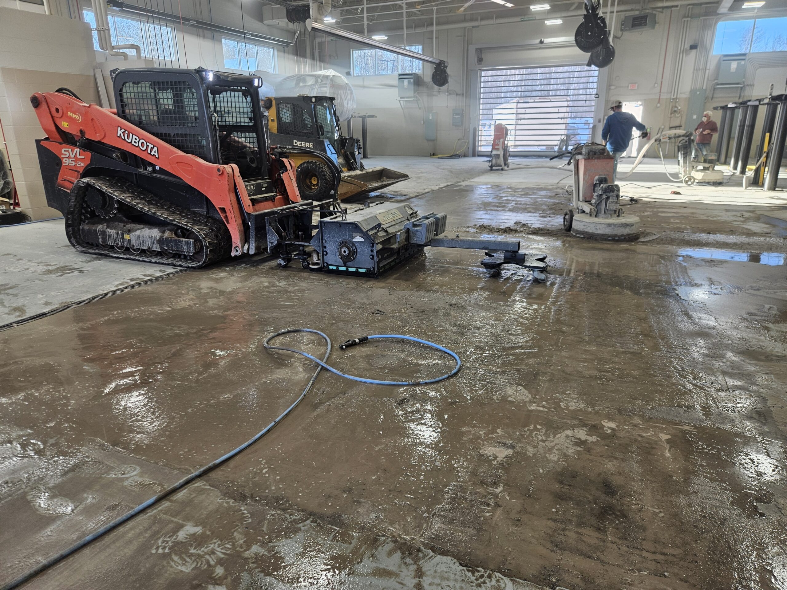 Floor grinding in progress showing heavy concrete prep equipment