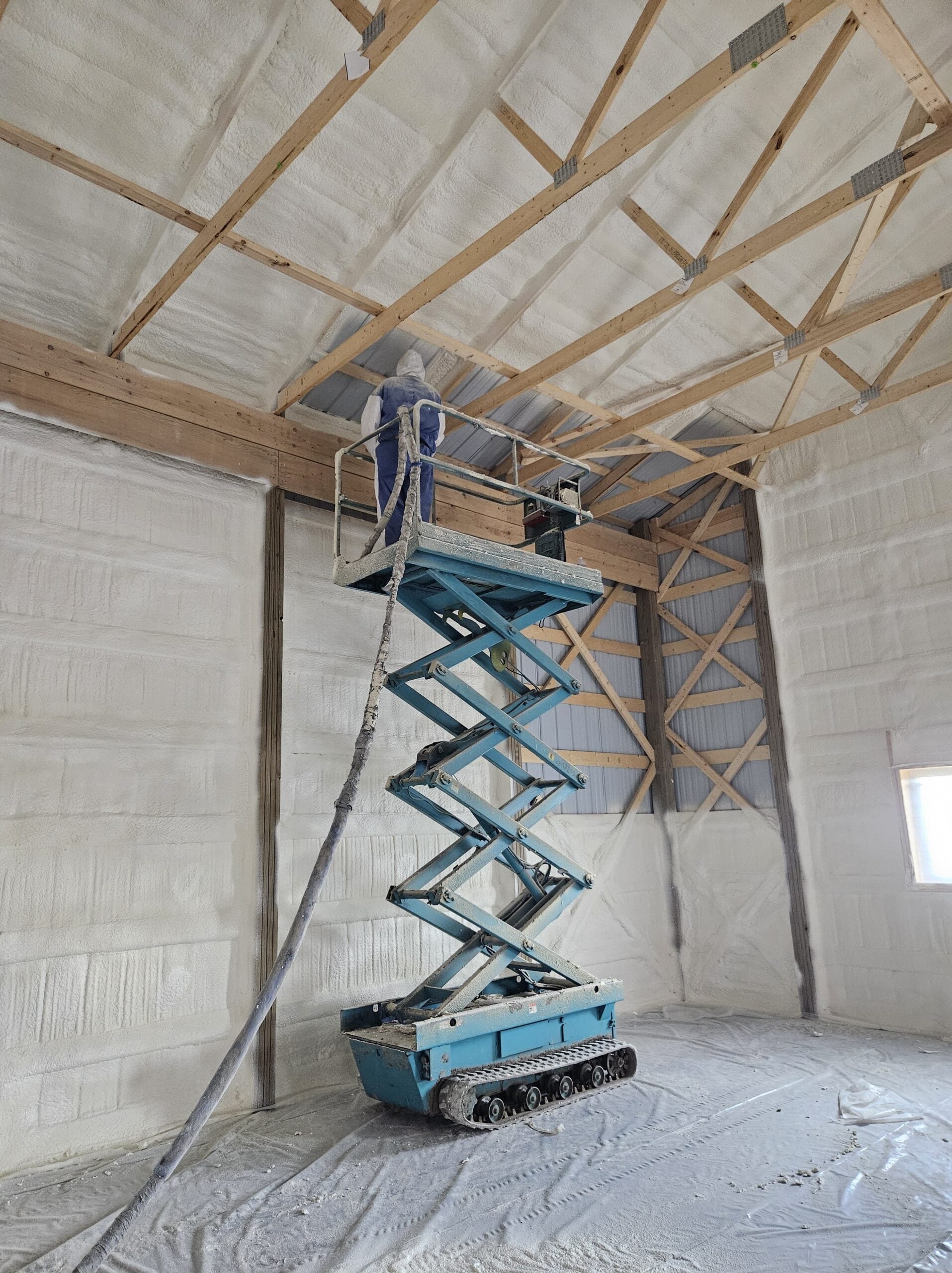 Worker applying closed-cell spray foam in Fargo ND commercial building