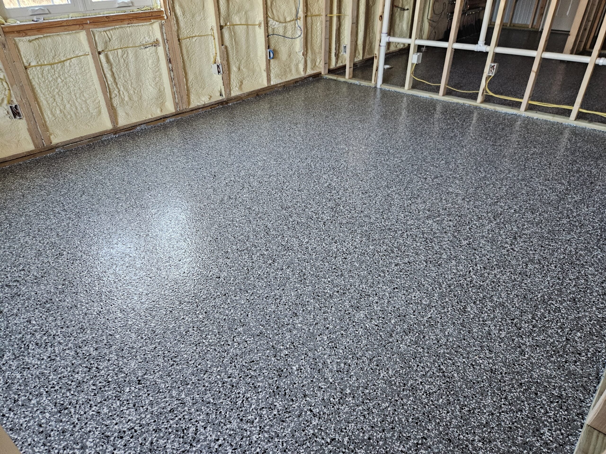 Flake epoxy floor coating applied precisely alongside insulated walls